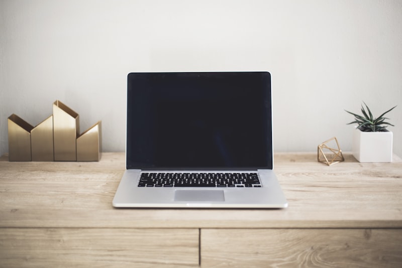 A laptop and notebook on a desk under warm light, ready for planning