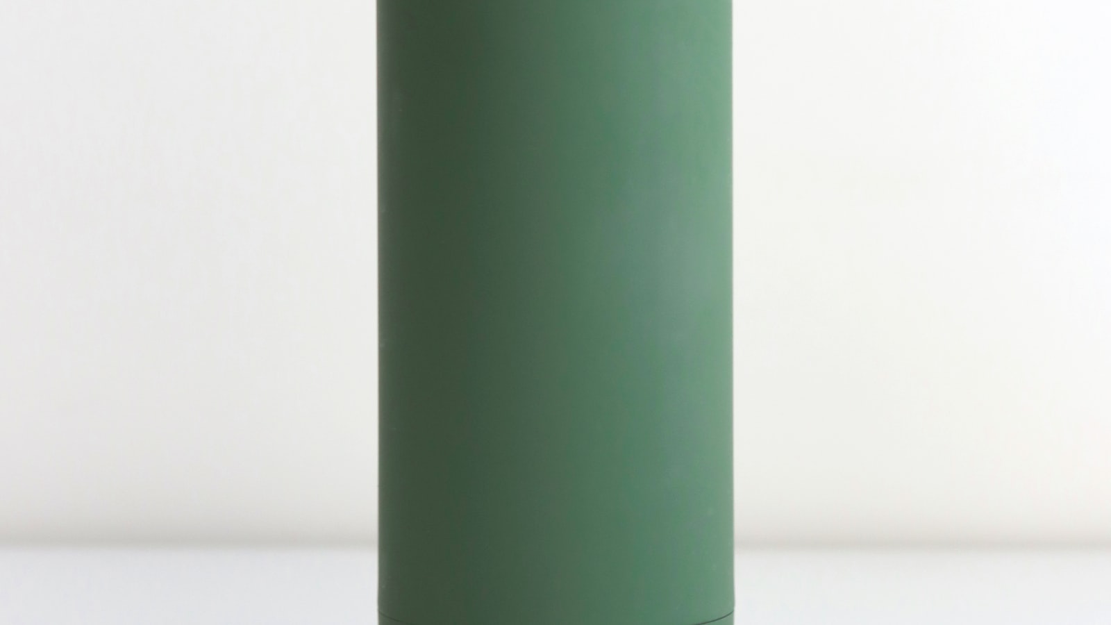 A smart speaker on a kitchen counter with its light ring glowing